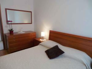 a bedroom with a bed and a dresser with a mirror at Apartments in Fazana/Istrien 8456 in Fažana