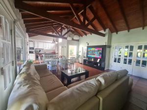 Una sala de estar con un sofá y un televisor. en Alquiler temporario Tandil LAS PALMERAS I, en Tandil