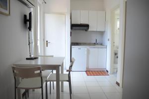 a kitchen with a table and chairs and a kitchen with white cabinets at Appartamenti Le Spiagge in Marciana Marina