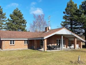 una casa de ladrillo con mesas y sillas en un patio en 8 person holiday home in R dby, en Kramnitse