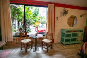 une chambre avec une table, des chaises et une fenêtre dans l'établissement Majikal B&B - Alebrijes, à Cholula
