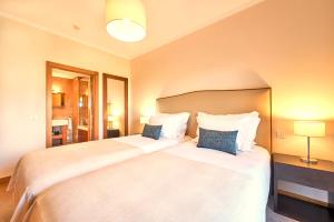 two beds in a hotel room with two pillows at Cascade Wellness Resort in Lagos