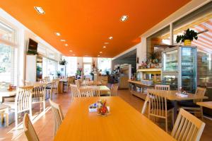 an empty restaurant with wooden tables and chairs at Ottenkellerhof in Bolzano