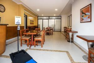 a restaurant with tables and chairs and a clock on the wall at Hotel El Campin in Bogotá