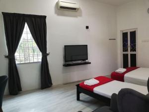 Habitación con 2 camas y TV de pantalla plana. en RoomStay Hj Esmon Parit Raja UTHM en Parit Raja