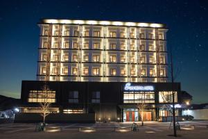 a large building with a sign in front of it at Sun Royal Hotel Kameoka Ekimae in Kameoka