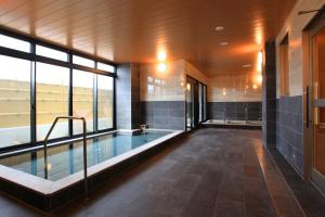 una grande piscina in un edificio con una grande finestra di Sun Royal Hotel Kameoka Ekimae a Kameoka