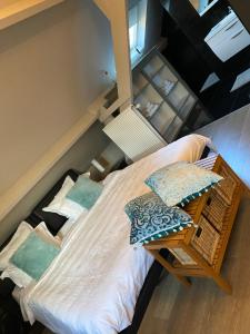 a bed with pillows on it in a room at Cosy Studio met Zwembad in Beringen +8 photos