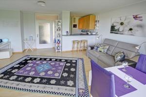 ein Wohnzimmer mit einem Sofa und einem Tisch in der Unterkunft fewo1846 - Bellevue - sonnige 2-Zimmer-Wohnung mit Balkon und Hafenblick in Flensburg