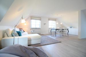 ein Wohnzimmer mit einem weißen Sofa und einem Tisch in der Unterkunft fewo1846 - Ahoi Marie - strandnahe Wohnung mit 3 Schlafzimmern in Flensburg