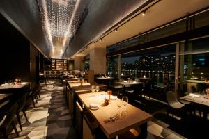 a restaurant with tables and chairs and a view of the city at The Gate Hotel Ryogoku by Hulic in Tokyo
