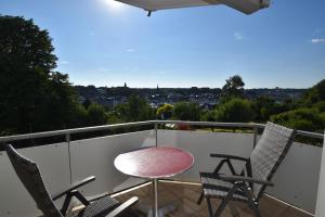 a balcony with a table and chairs and a view at fewo1846 - FoerdeView - luxuriöse Wohnung mit 2 Schlafzimmern und Balkon mit Hafenblick in Flensburg