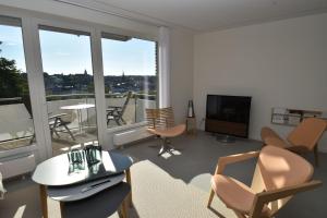 a living room with chairs and a flat screen tv at fewo1846 - FoerdeView - luxuriöse Wohnung mit 2 Schlafzimmern und Balkon mit Hafenblick in Flensburg
