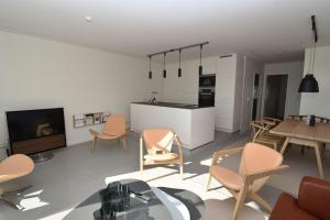 a living room with chairs and a table and a kitchen at fewo1846 - FoerdeView - luxuriöse Wohnung mit 2 Schlafzimmern und Balkon mit Hafenblick in Flensburg