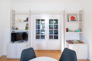 ein Wohnzimmer mit weißen Regalen und einem TV in der Unterkunft fewo1846 - Heimspiel - komfortable Wohnung mit 2 Schlafzimmern und sonnigem Garten in Flensburg