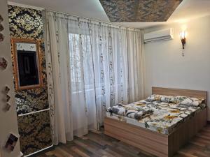 a bedroom with a bed and a large window at Garsoniera Gara de Nord in Bucharest