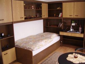 a bed in a room with wooden cabinets and a table at ABT Private Rooms Hannover Exhibition Ground (room agency) in Hannover