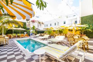 
a patio area with tables, chairs and umbrellas at Clinton Hotel South Beach in Miami Beach

