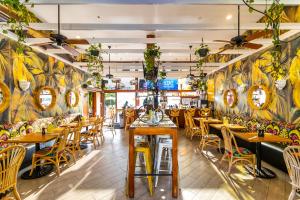 un restaurante con mesas y sillas de madera y paredes coloridas en Clinton Hotel South Beach, en Miami Beach