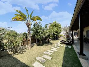 einen Garten mit einer Palme und einem Weg in der Unterkunft 花宿 民宿 in Xiaoliuqiu