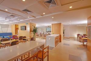 um átrio com mesas e cadeiras e uma cafetaria em Holiday Inn Express Tangshan Downtown, an IHG Hotel em Tangshan
