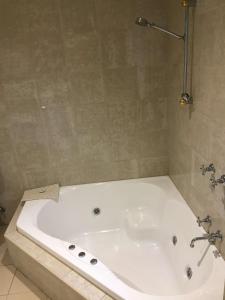 a white bath tub in a bathroom at Best Western Plus The Tudor Box Hill in Box Hill