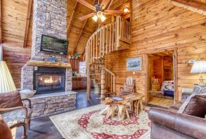 a living room with a fireplace in a log cabin at A Waterfall Retreat- Waterfall, Cozy Cabin Retreat in the Smokies Comfort & Fun for All in Sevierville