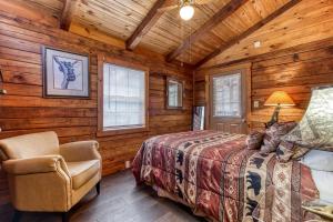 a bedroom with a bed and a chair in a cabin at A Waterfall Retreat- Waterfall, Cozy Cabin Retreat in the Smokies Comfort & Fun for All in Sevierville