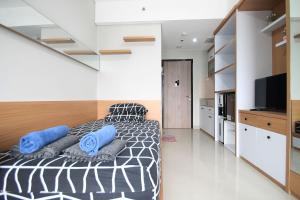 sypialnia z czarno-białym łóżkiem z niebieskimi poduszkami w obiekcie Apartemen Monroe Jababeka Cikarang Bekasi by Aparian w mieście Bekasi