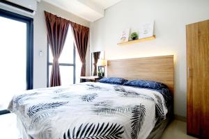 a bedroom with a bed with a black and white comforter at Apartemen Monroe Jababeka Cikarang Bekasi by Aparian in Bekasi +18 photos