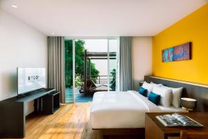 a hotel room with a bed and a tv at RELO' The Urban Escape - Huahin in Cha Am