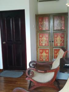 Pokój z dwoma krzesłami i drzwiami w obiekcie The Villa Hotel w mieście Unawatuna