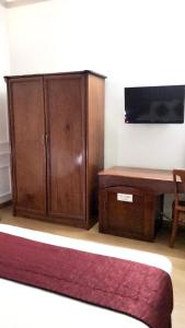 a living room with a wooden cabinet and a table at Huyen Tran Hotel in Can Tho