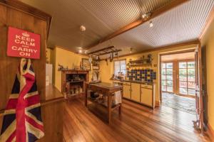 Habitación con cocina con mesa y cartel en Barossa Valley’s Captain Rodda’s Cottage en Angaston