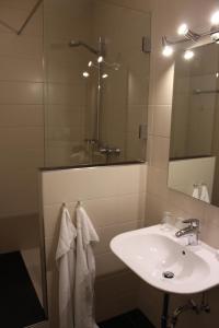 a white bathroom with a sink and a mirror at Hotel zur Moselbrücke in Schweich