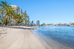 a beach with palm trees and buildings in the background at Crown Towers Resort Apartments in Gold Coast