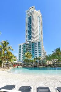 a resort with chairs on the beach and a building at Crown Towers Resort Apartments in Gold Coast