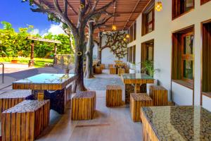 a patio with tables and benches and a tree at Club Mahindra Netrang in Netrang