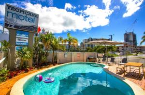 a swimming pool with a swimming pool table and chairs at Tropicana Motel in Gold Coast