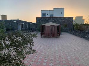 een patio met een tent en een gebouw bij Aljabal Al Akhdar Olive Tree Guest house in Al ‘Aqar