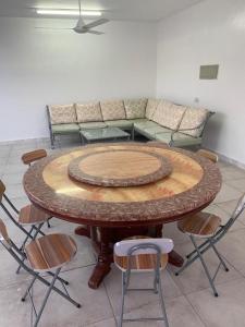 a large wooden table with chairs and a couch at Aljabal Al Akhdar Olive Tree Guest house in Al ‘Aqar