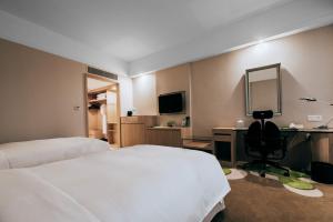 Holiday Inn Changzhou Wujin, an IHG Hotel في تشانغتشو: غرفة في الفندق بها سرير ومكتب ومرآة