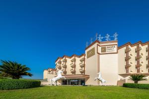 a hotel with two statues of horses outside of it at Amara Family Resort in Side