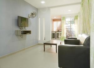 Corrie Chalet Langkawi في بانتايْ سينانج: غرفة معيشة مع أريكة وطاولة