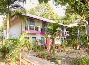 a house with a lot of plants in front of it at Corrie Chalet Pantai Cenang Langkawi in Pantai Cenang