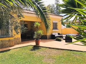 una casa amarilla con un patio delante en Casita Bella en Chiclana de la Frontera