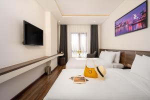 a hotel room with two beds and a television at Tan Phuong Nam Hotel & Apartment in Da Nang