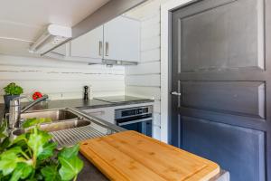 a kitchen with a sink and a stove at Senja Fjordcamp in Torsken