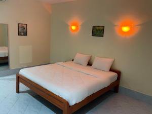 a bedroom with a bed with two pillows on it at GPM Resort Pattaya in Jomtien Beach
