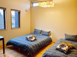 two beds in a room with two windows at BALLAD HOUSE / Vacation STAY 31548 in Yachimata
